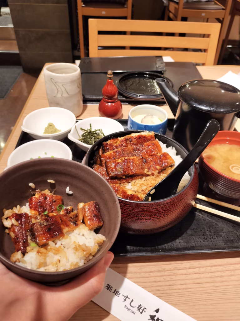 The first serving in the smaller bowl showing proper presentation with sanshō pepper, demonstrating traditional hitsumabushi eating method.